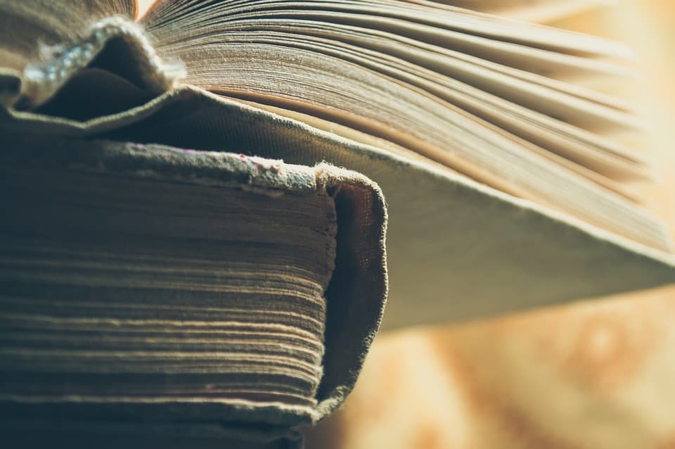 Stack of worn hardcover books, a bookish gift still life