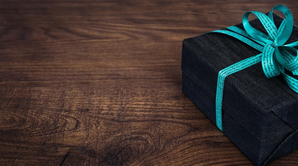 A wrapped gift box with a gold bow waiting to be opened